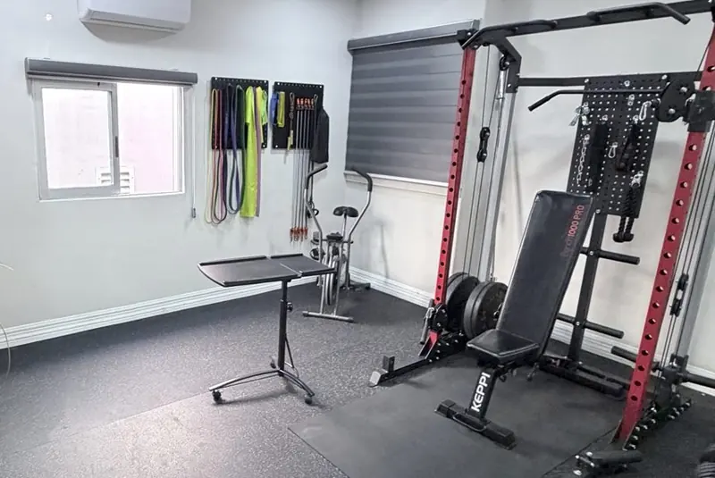 Sala de entrenamiento de PhysioPro: rack, banco y bandas de resistencia.